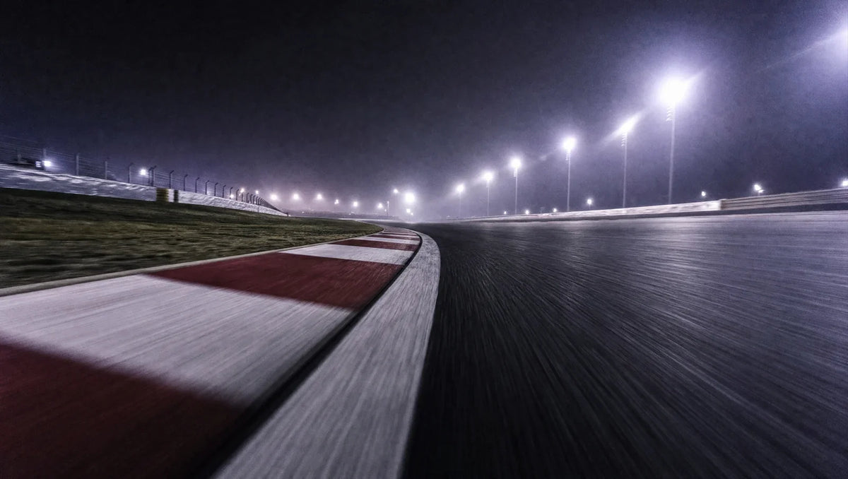 Night race circuit corner with red and white kerbs